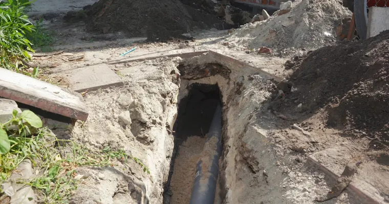 Excavated sewer pipe and repair trench outside a property for Industrial Sewer Line Repair in Tolleson, AZ in Tolleson industrial corridor The repair area is visible from a closer angle.