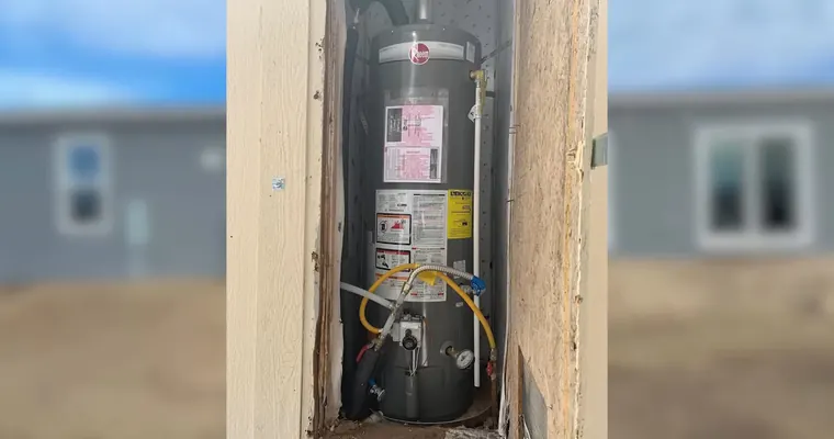 Tank water heater with gas, vent, and supply connections for Why Tolleson Water Heaters Fail Earlier Than the Box Says They Should The repair area is visible from a closer angle.