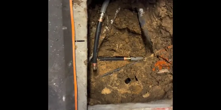 Under-slab plumbing repair area with concrete or soil opened for Caliche Soil and Hard Water: Why Slab Leaks Are More Common in Tolleson The repair area is visible from a closer angle.
