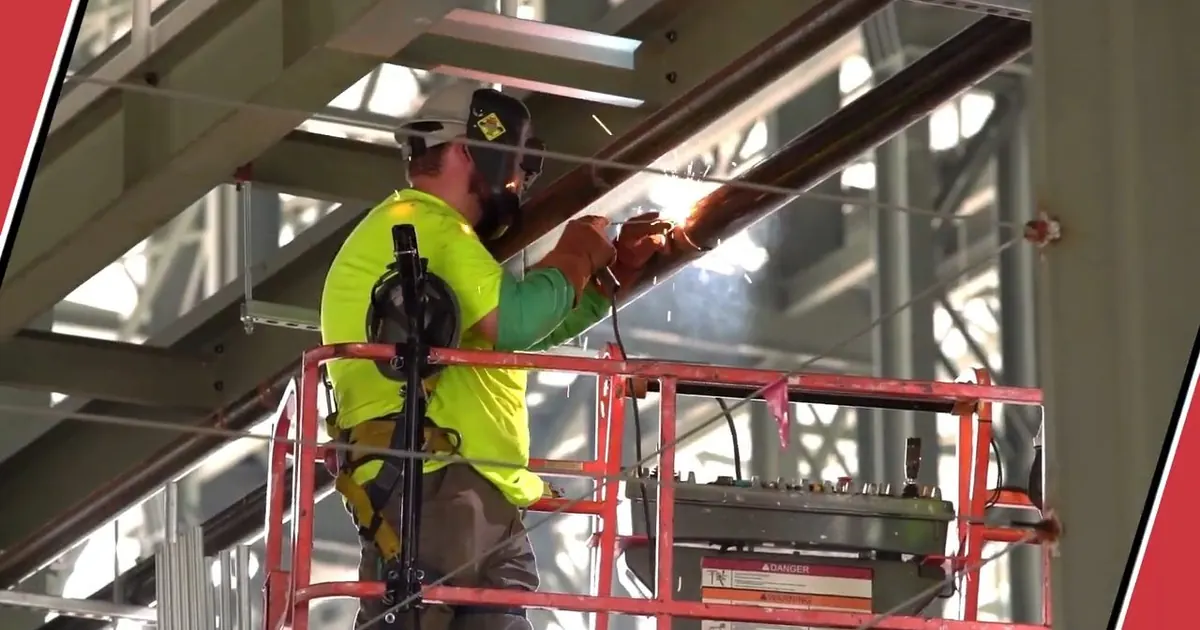 Technician working from a lift on overhead warehouse piping for From the Vegetable Center of the World to Fortune 500 Hub: Tolleson's Plumbing Story in Original Tolleson